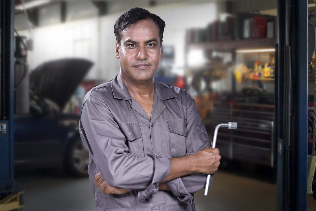 digital-01 Portrait of a skilled mechanic holding a lug wrench in a Karachi auto repair shop.